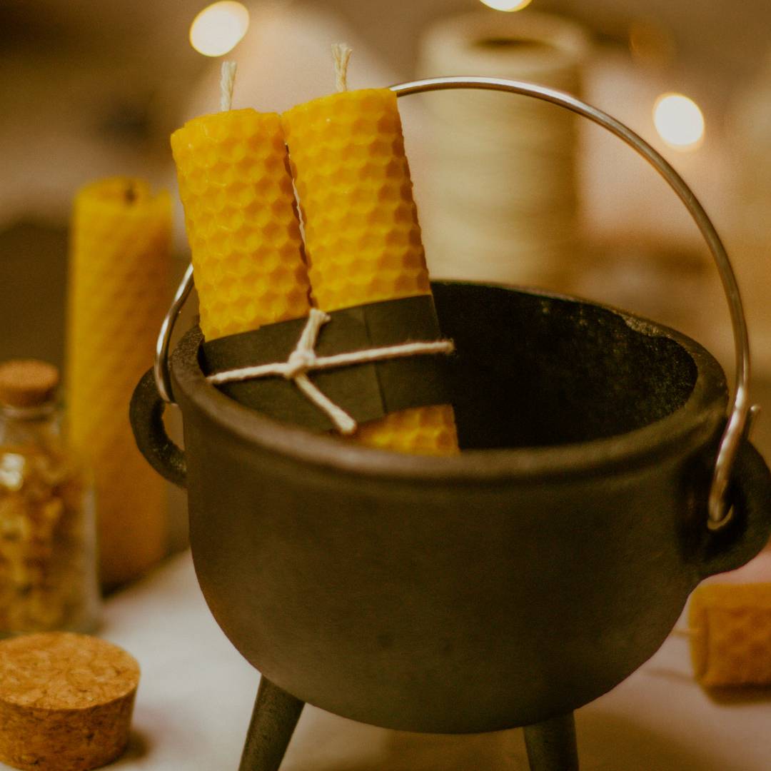 A little cauldron with beeswax candles inside of it