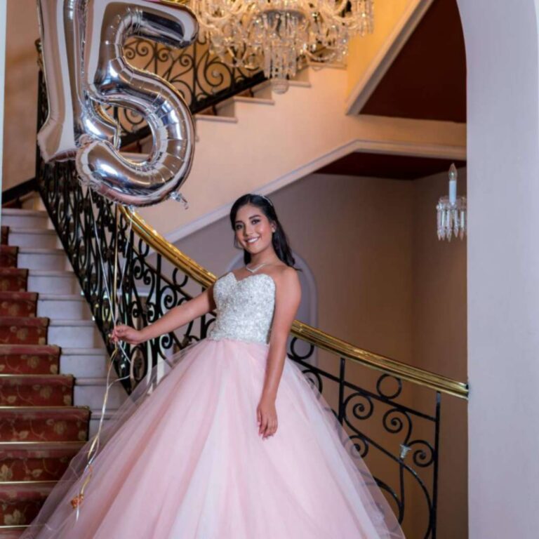 Young girl in a beautiful fancy dress holding a balloon in the shape of the number 15
