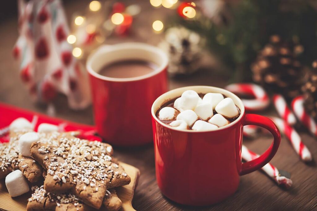 Mugs of hot cocoa with topping options and cookies